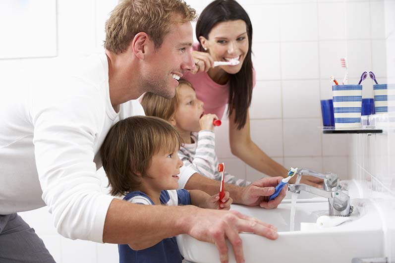 Family In Bathroom Brushing Teeth